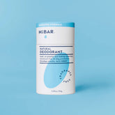 The white and light blue plastic-free cardboard tube of HiBAR's Fragrance-Free Natural Deodorant for sensitive skin, shown closed against a solid blue background.