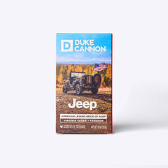 Front of the Duke Cannon Jeep American Legend brick of soap box showing a Willys Jeep with an American flag in an autumn forest landscape