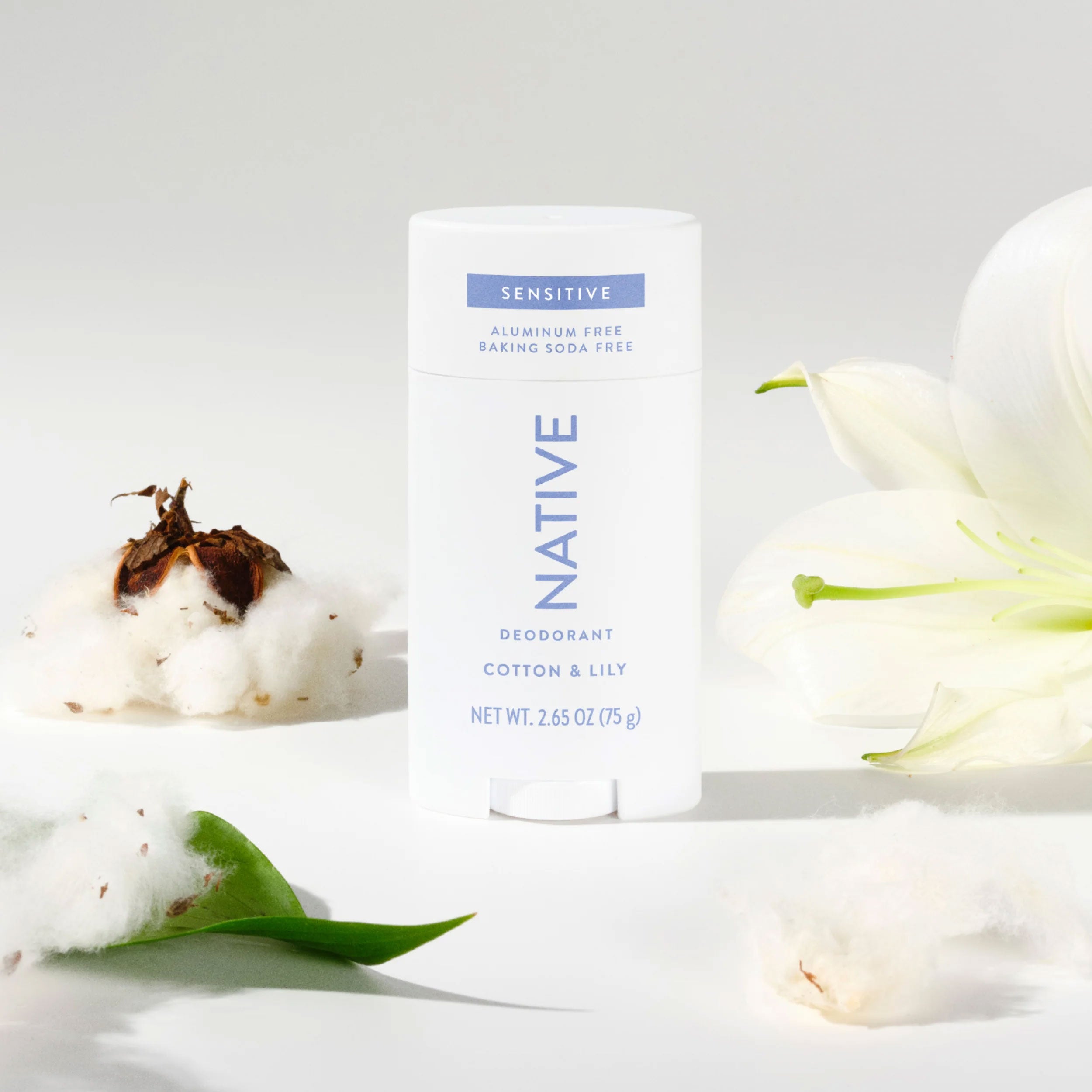 Native Cotton & Lily deodorant stick styled with raw cotton bolls and a white lily flower on a soft white background