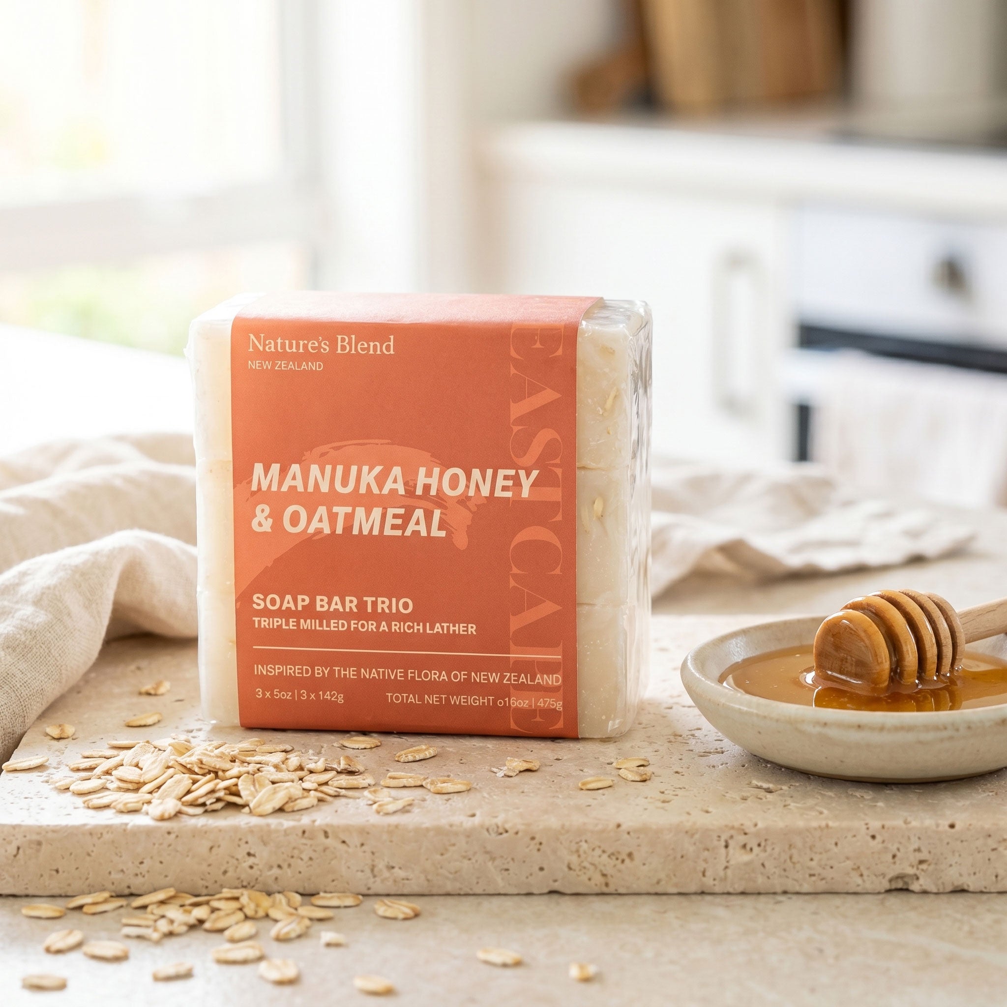 Nature's Blend Manuka Honey and Oatmeal soap trio on travertine kitchen counter with scattered rolled oats and a small dish of honey with wooden dipper