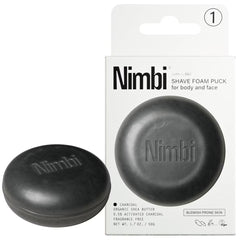 Top-down view of Nimbi charcoal shave foam puck with embossed Nimbi logo on dark grey solid soap bar