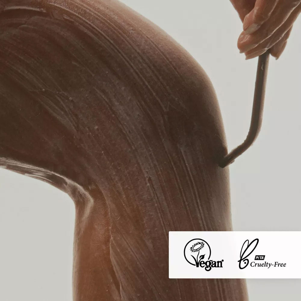 Close-up of lathered Nimbi shave foam on a leg with razor in mid-stroke, displaying Vegan and PETA Cruelty-Free badges