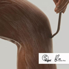 Close-up of lathered Nimbi shave foam on a leg with razor in mid-stroke, displaying Vegan and PETA Cruelty-Free badges