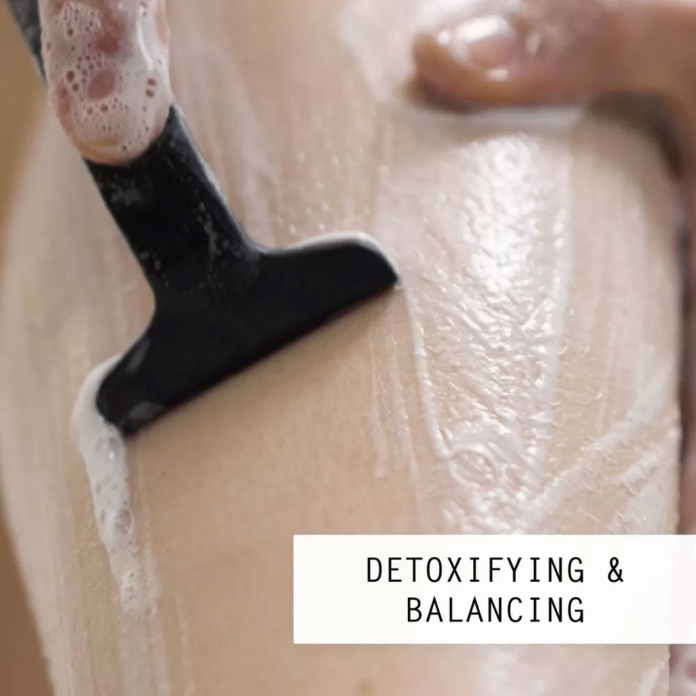 Razor gliding through thick white Nimbi shave foam on skin with Detoxifying and Balancing label
