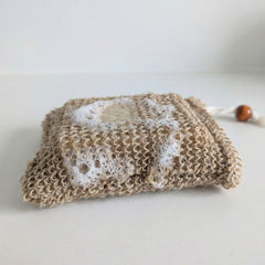 Hemp soap bag with lathered bar soap showing exfoliating texture and foam creation