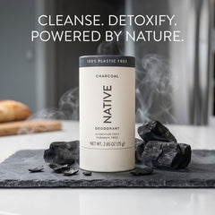 Native Charcoal plastic-free deodorant tube styled on a slate board with chunks of charcoal and rising smoke, headline reading "Cleanse. Detoxify. Powered by Nature."