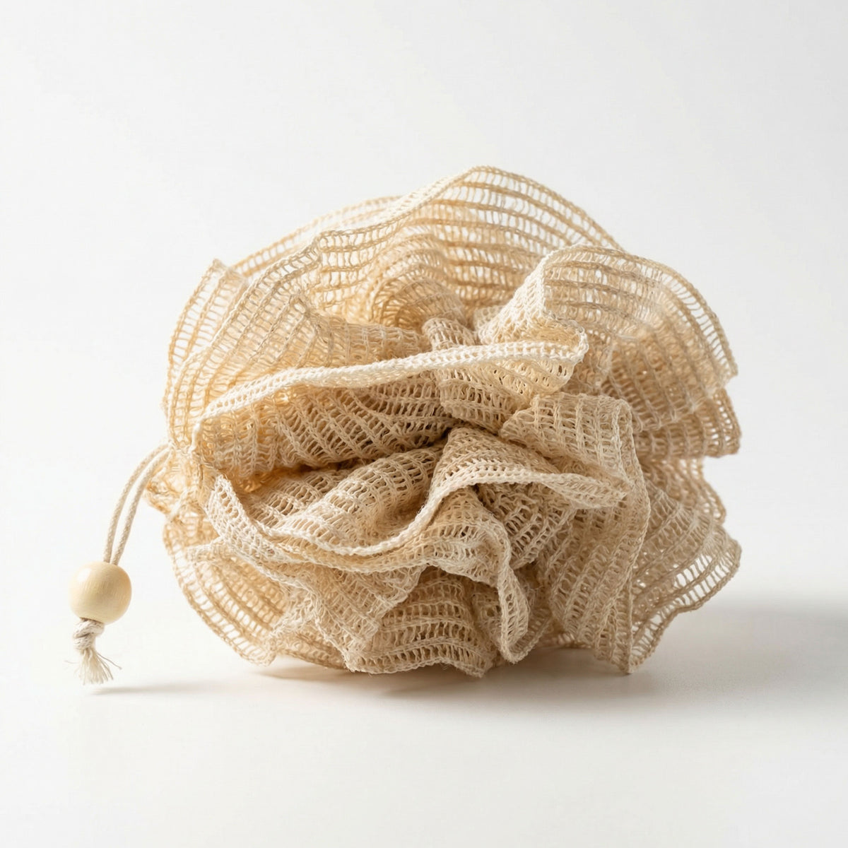 Natural ramie bath pouf with layered mesh construction and cotton hanging cord with wooden bead toggle