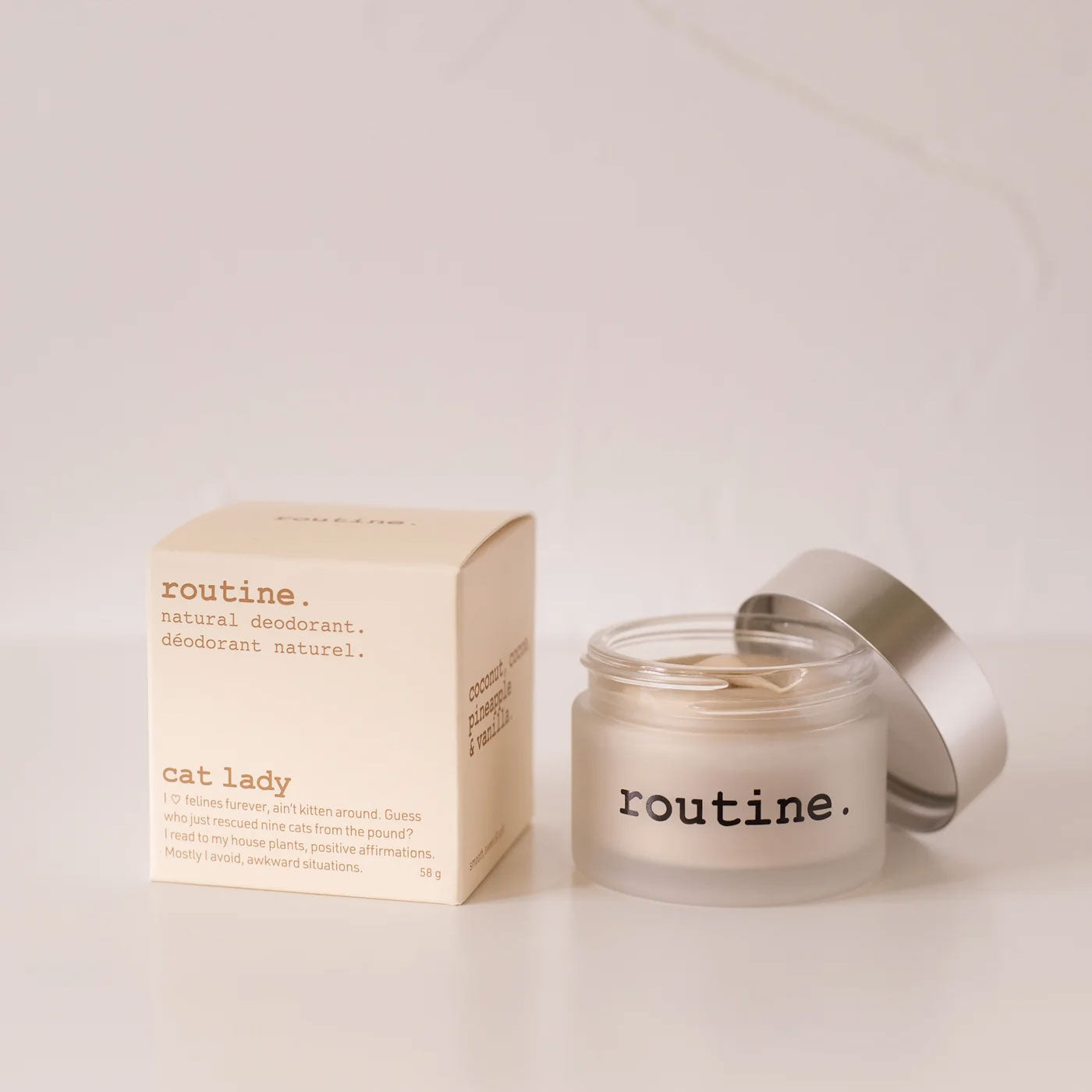 routine Cat Lady natural deodorant jar - cream-coloured glass container with silver lid next to branded cardboard box showing 58g vegan formula for sensitive skin