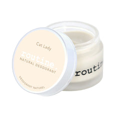routine Cat Lady deodorant jar opened - showing smooth white cream texture inside glass container with "Cat Lady Natural Deodorant" label for coconut vanilla scented formula