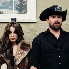 Country-style couple in black outfits representing the rebellious, authentic aesthetic of Routine Johnny's Cash deodorant's target audience inspired by outlaw culture