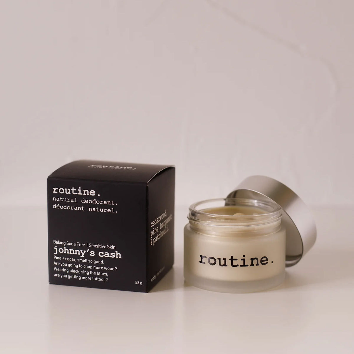 Routine Johnny's Cash baking soda free natural deodorant - glass jar with cream deodorant beside black packaging highlighting sensitive skin formula with cedar and pine scent