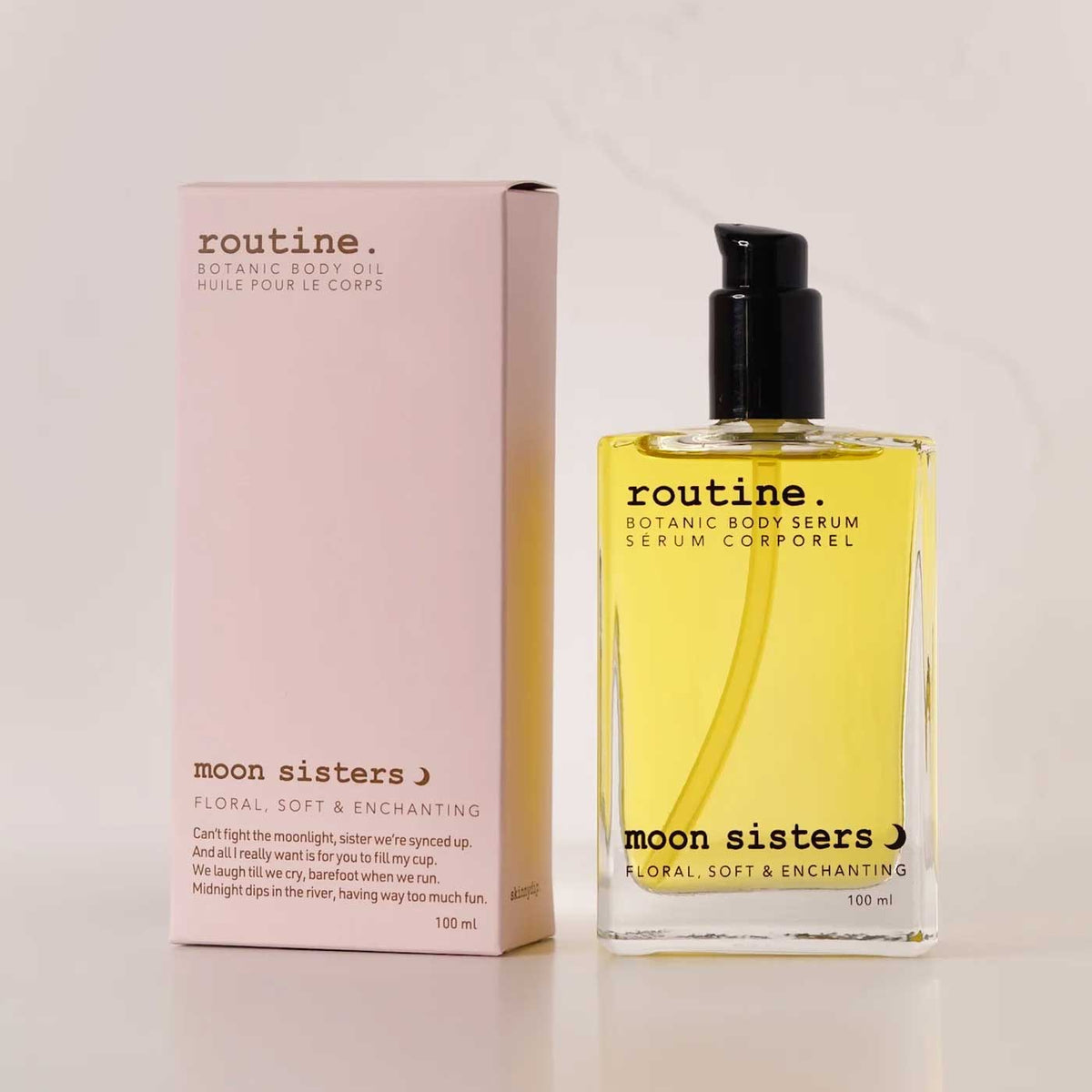 routine Moon Sisters Botanic Body Oil in 100ml glass bottle with black pump next to soft pink cardboard packaging showing floral, soft & enchanting scent description