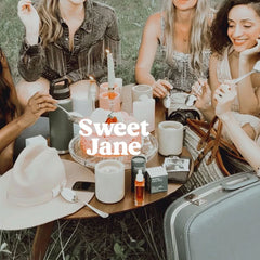 Sweet Jane natural deodorant lifestyle scene - five women enjoying outdoor picnic with Routine products displayed on wooden table - showcasing natural beauty and friendship moments