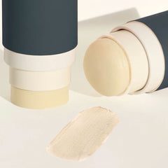 A twist-up stick of Routine The Class deodorant in a navy-blue and white tube—one stick standing upright and another lying on its side to reveal the pale yellow balm—with a matching smear of deodorant on a light cream surface beneath.