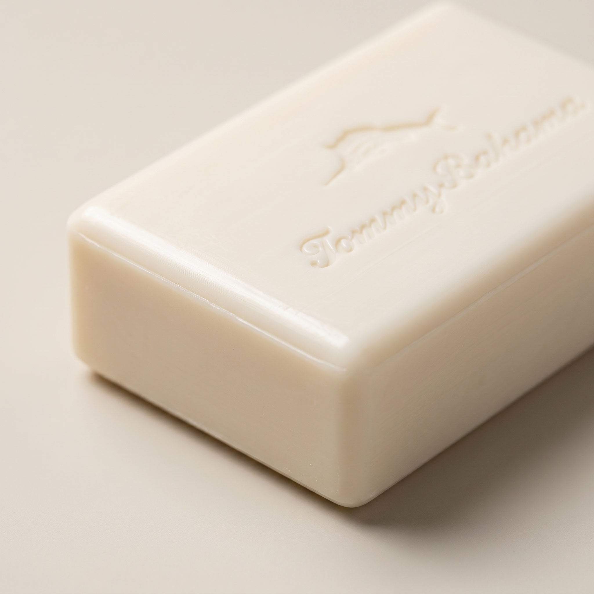 Close-up of unwrapped Tommy Bahama bar soap showing the embossed marlin logo and brand script on the cream-coloured bar surface